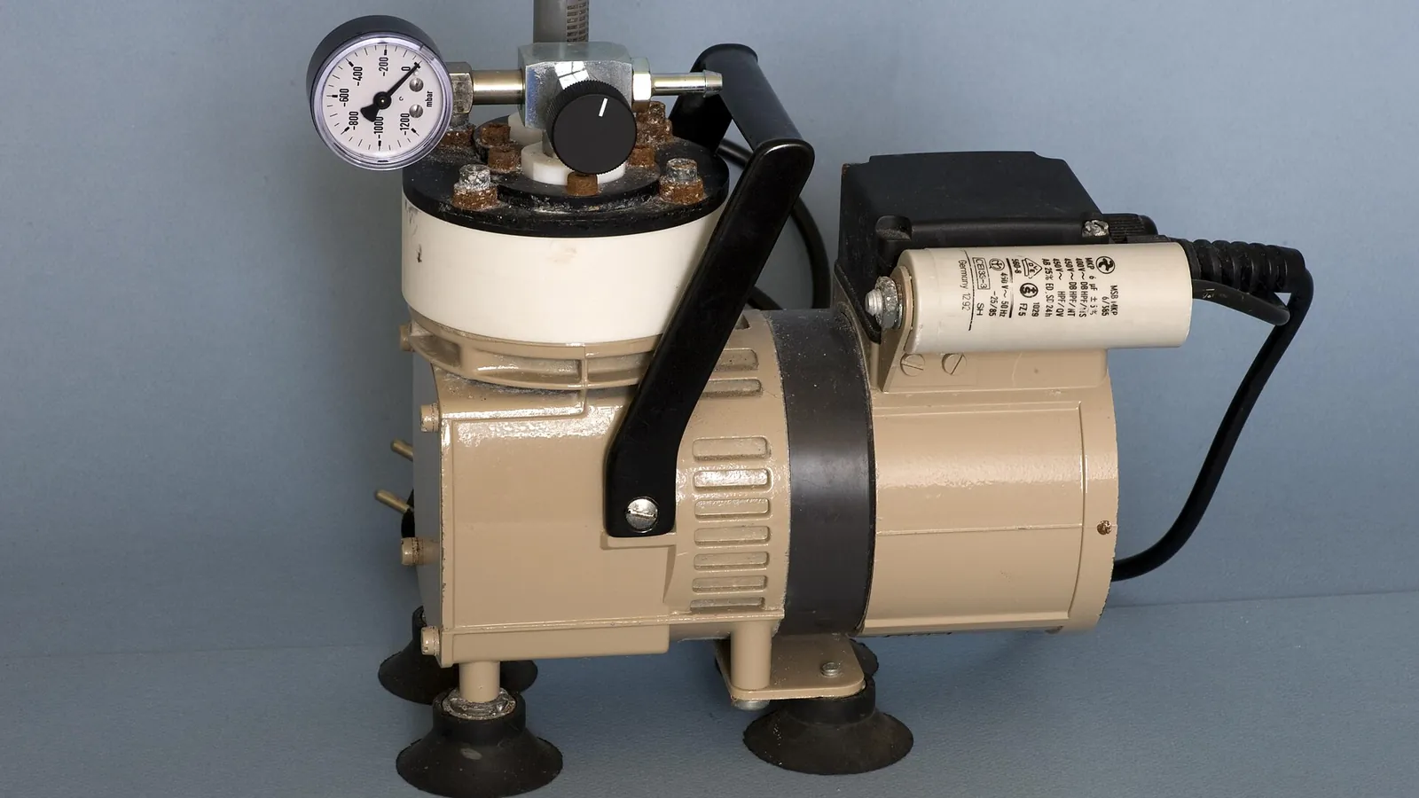 Laboratory vacuum pump with pressure gauge generating vacuum on a bench