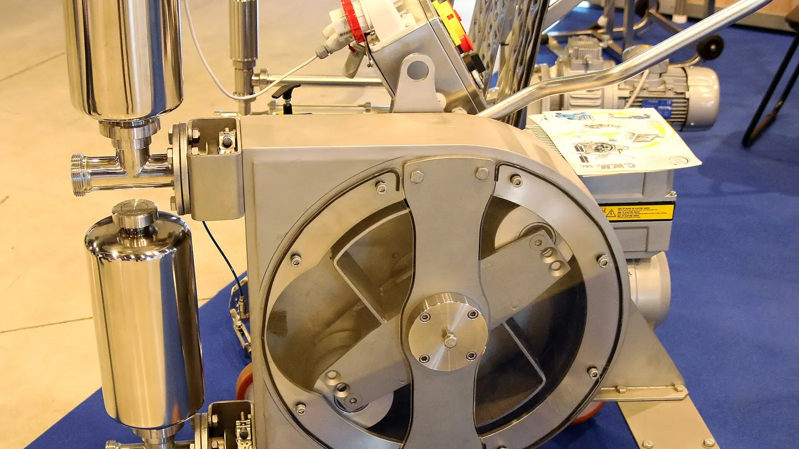 Large stainless-steel industrial peristaltic pump on casters in a plant