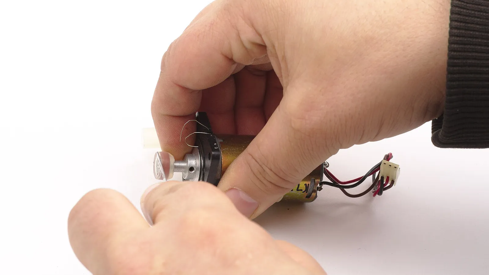 Hands holding a peristaltic pump head and drive motor
