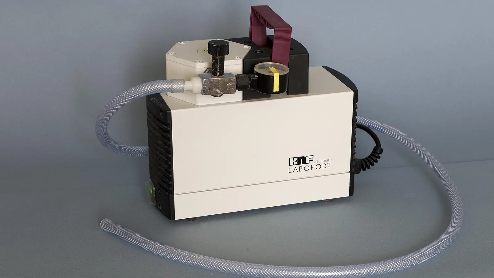 Laboratory pump with coiled grey tubing in a filtration setup