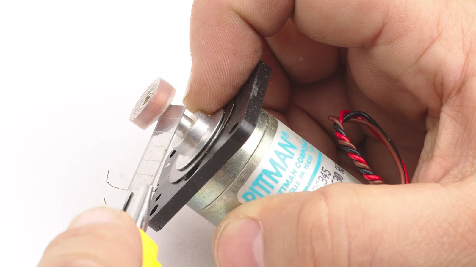 Hands fitting a roller onto a peristaltic pump head